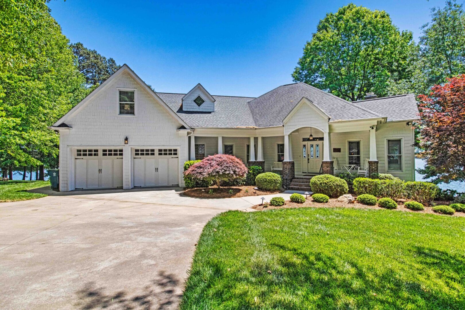 A large white house with two garage doors.