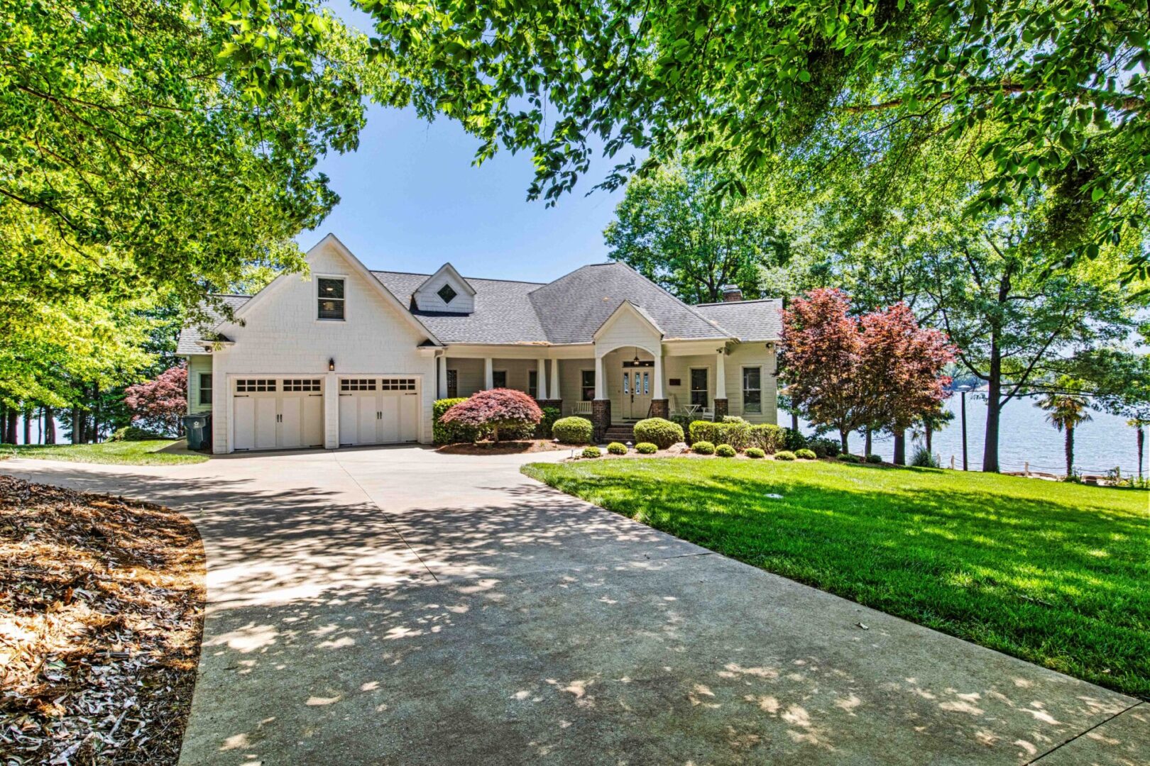 A large white house with a driveway in front of it.