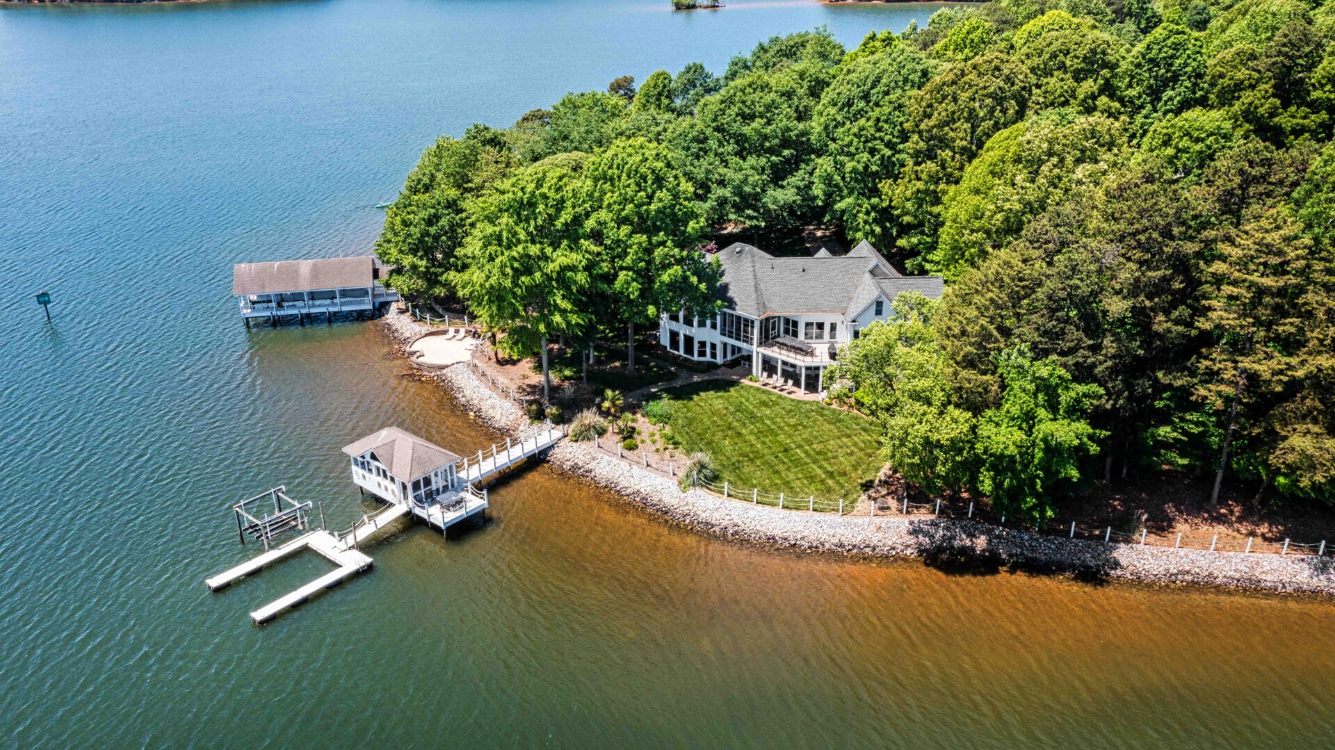 A house on the water with a dock in front of it.