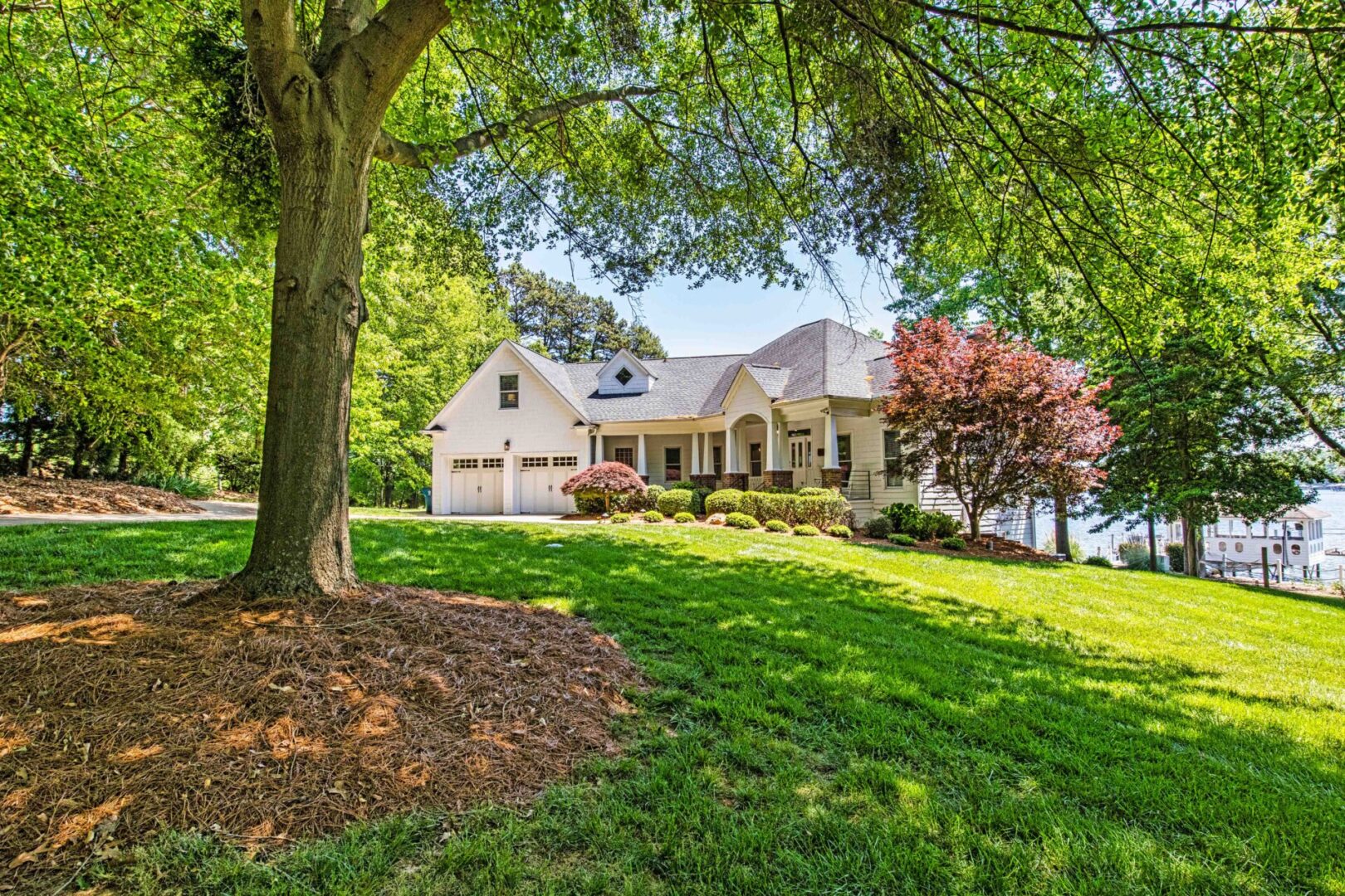 A large white house sitting on top of a green hill.