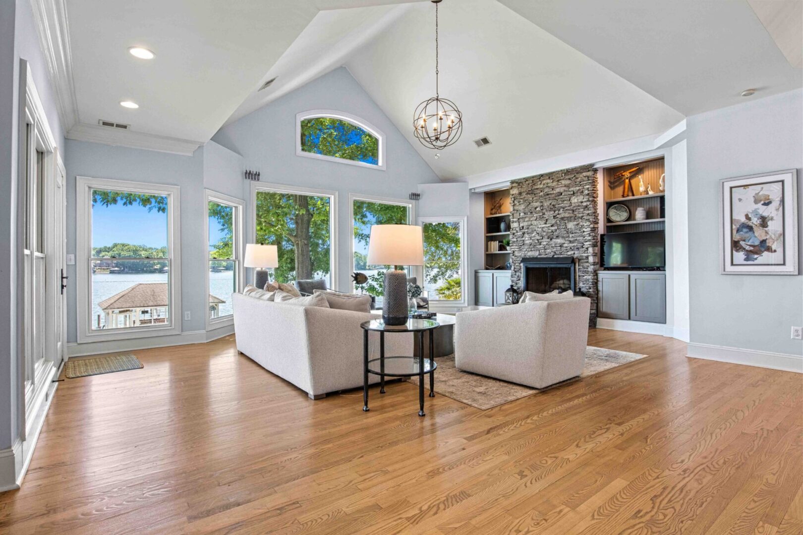 A living room with hard wood floors and vaulted ceilings.