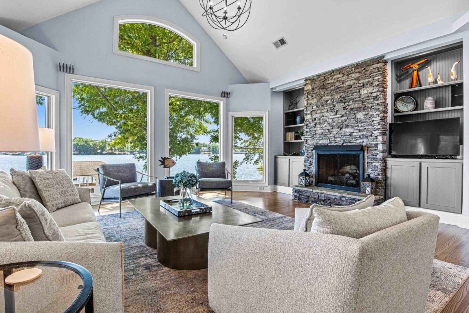 A living room with a fireplace and large windows.