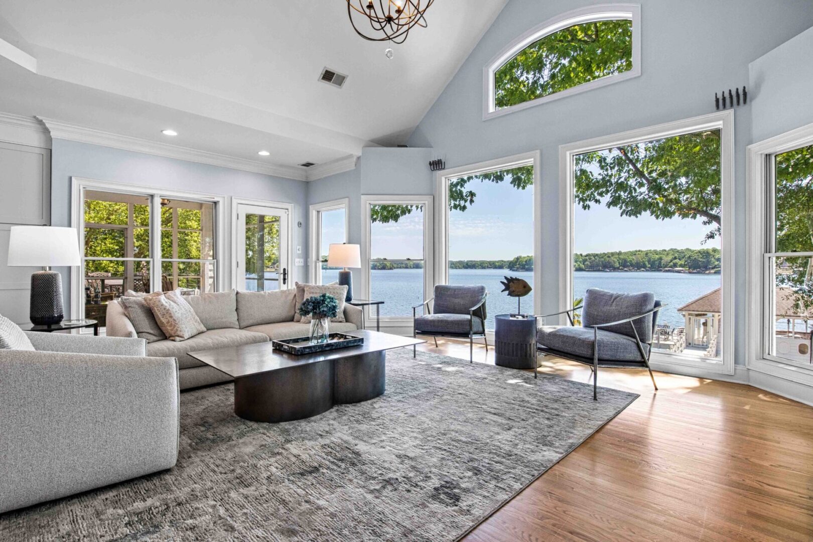 A living room with large windows and a lake view.