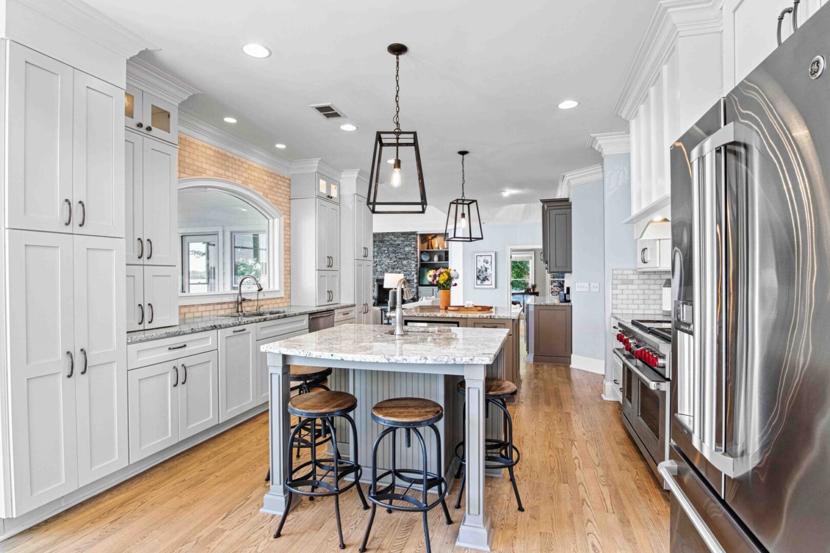 A kitchen with white cabinets and wooden floors.