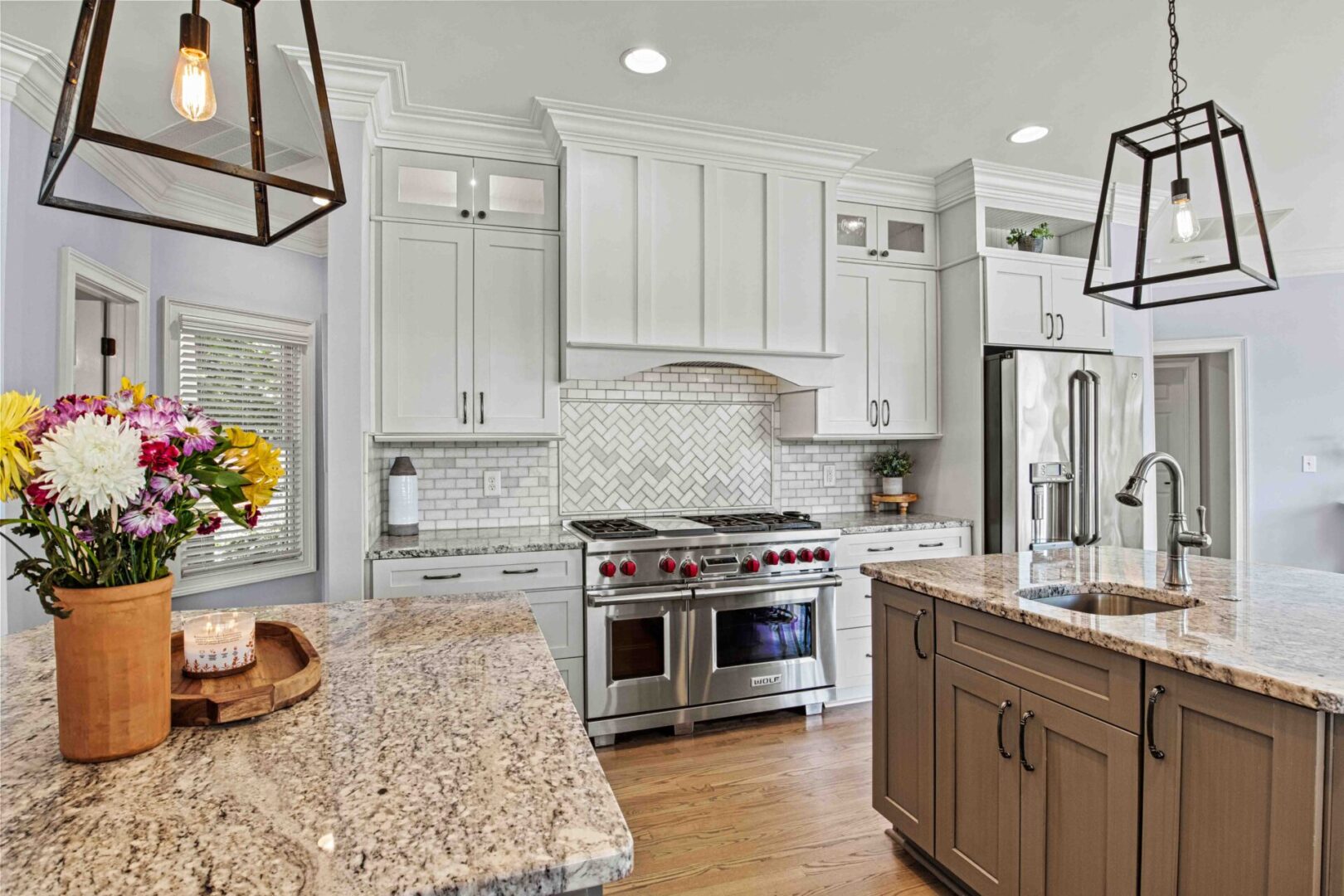 A kitchen with white cabinets and granite counter tops.