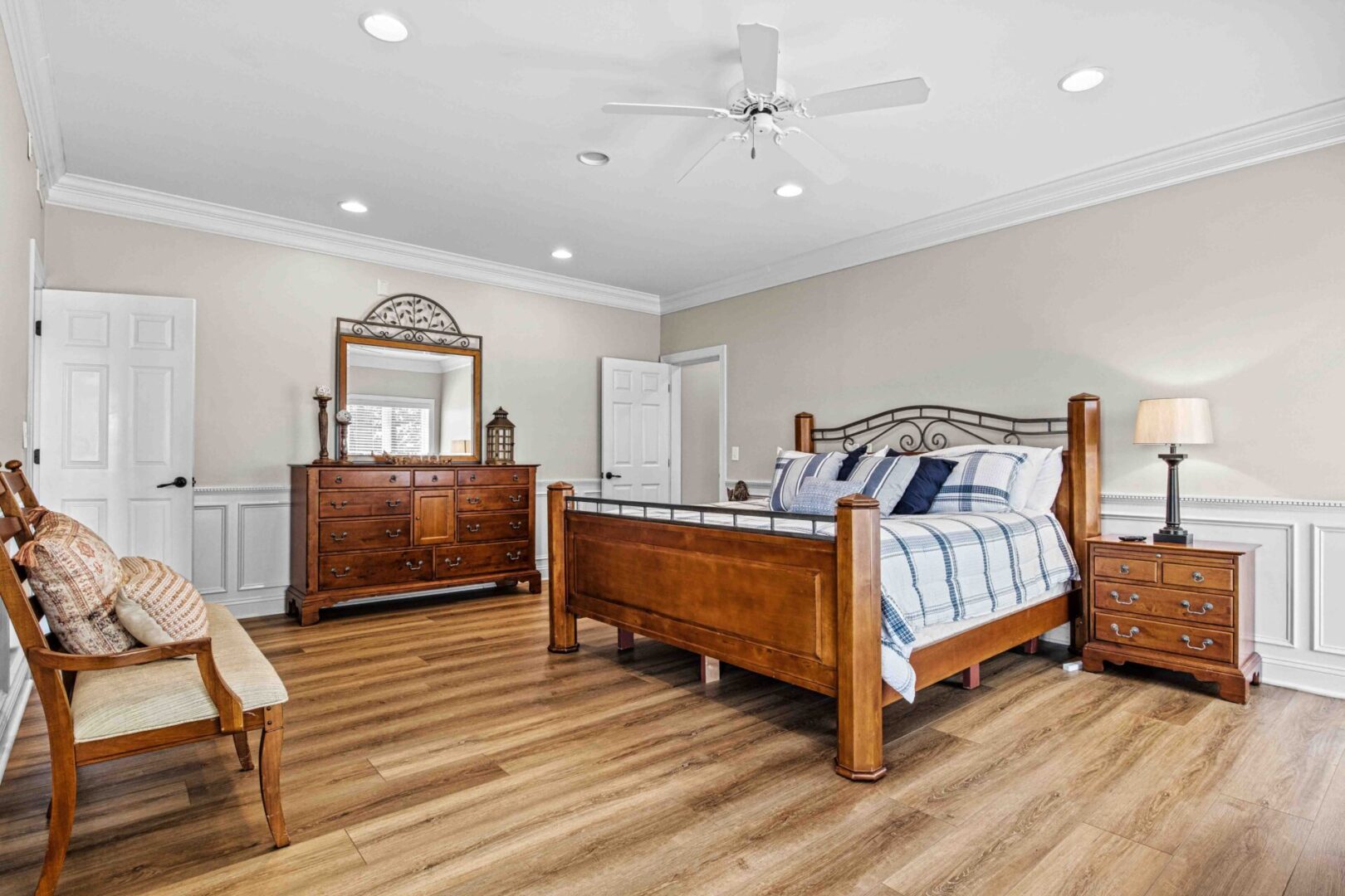 A bedroom with hard wood floors and a large bed.