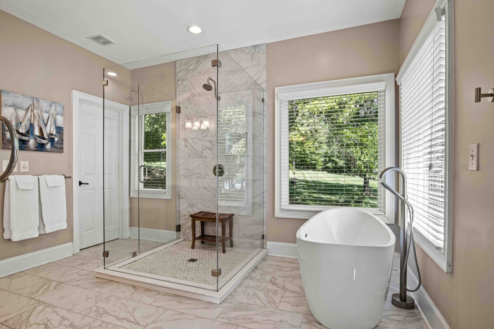 A bathroom with a large glass shower and a tub.