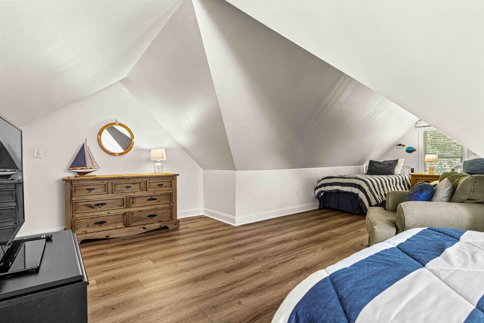 A bedroom with two beds and a dresser in it.