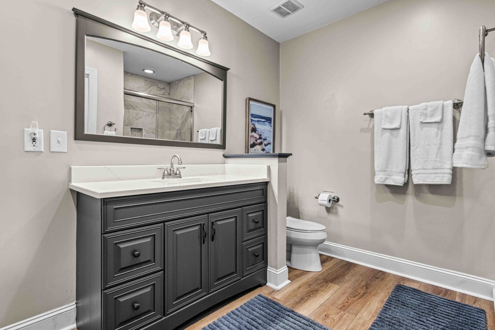 A bathroom with a sink, mirror and toilet.