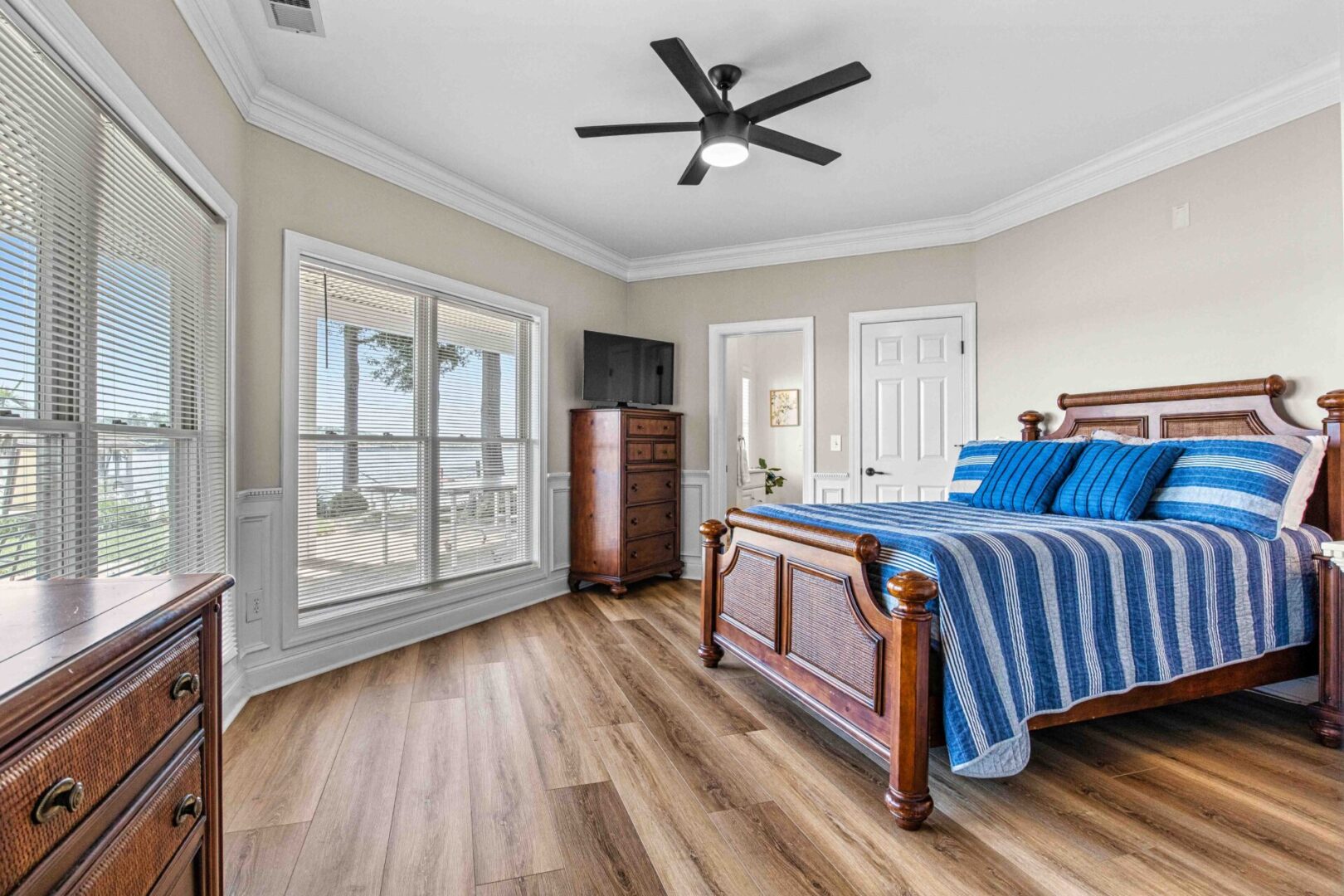 A bedroom with hardwood floors and a bed.