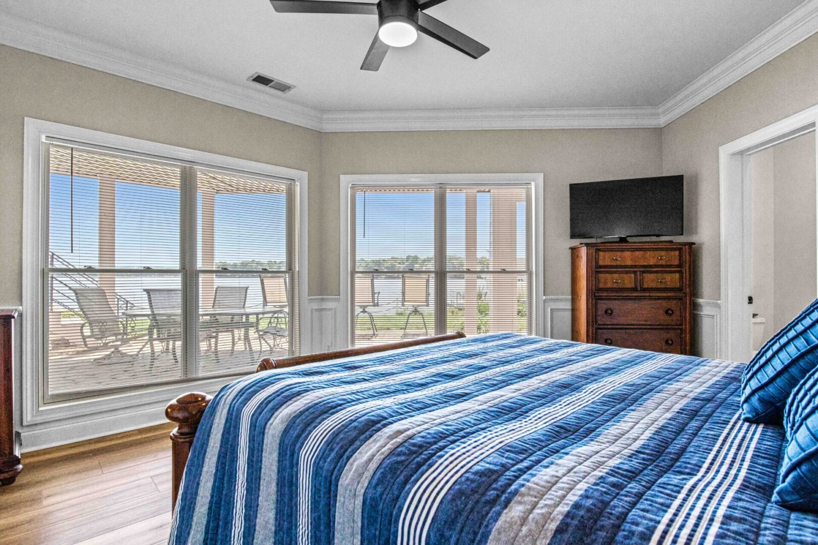 A bedroom with a bed, dresser and tv.