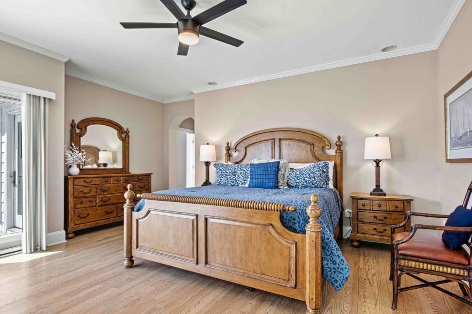 A bedroom with a bed, dresser and mirror.