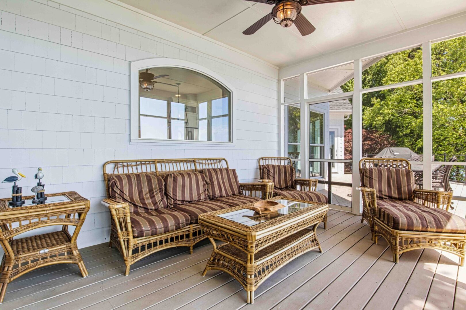 A porch with furniture and a table on the side.