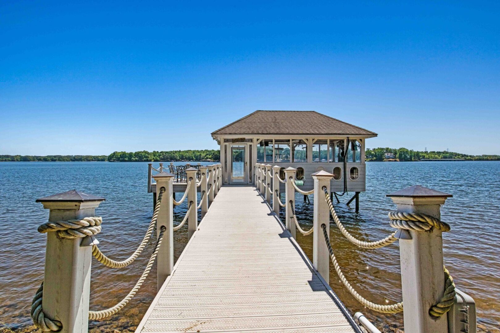 A dock with a house on it and water