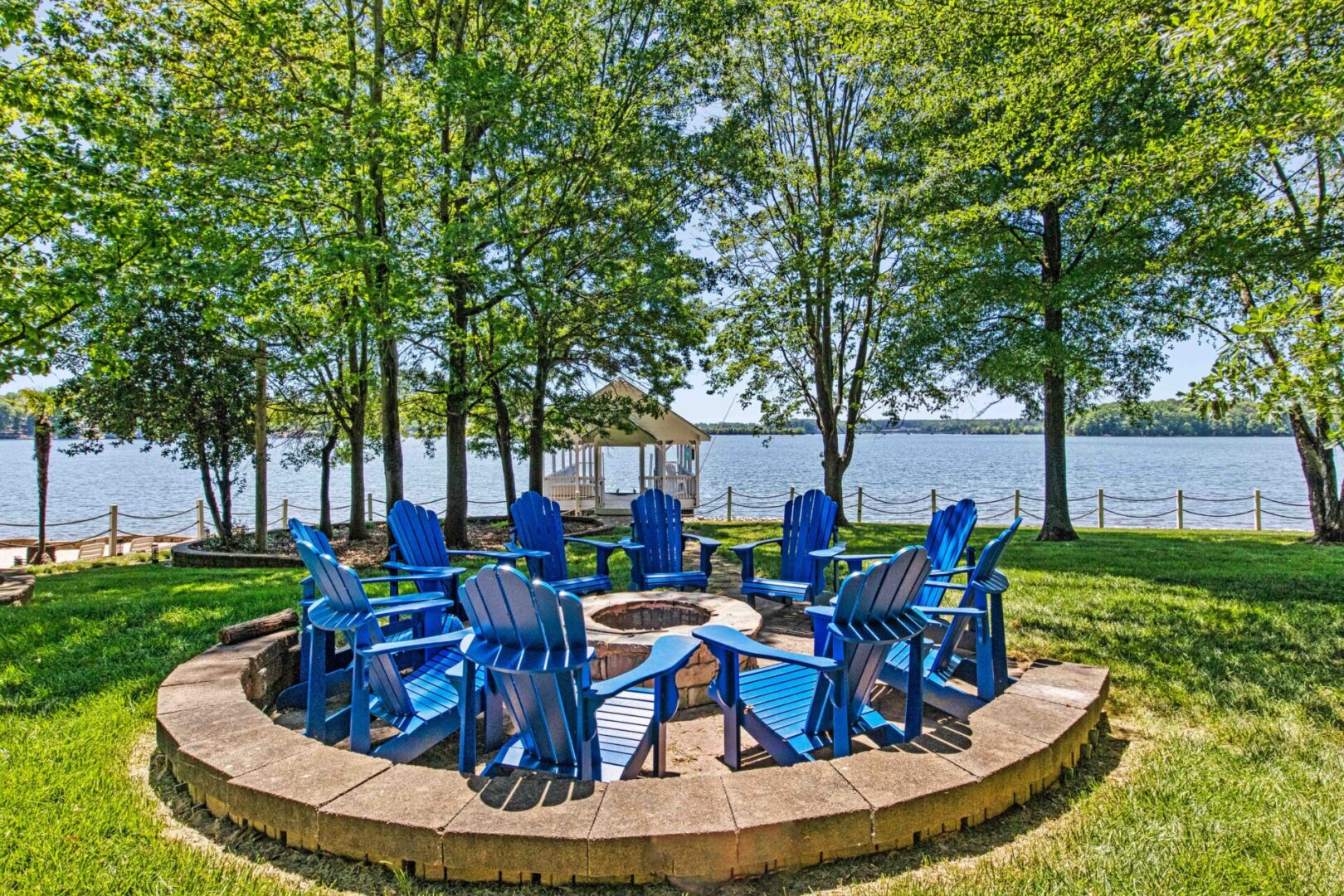 A group of blue chairs around a fire pit.